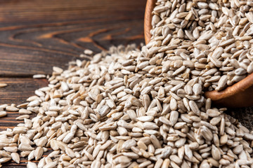 Obraz premium Sunflower seeds on dark wooden background.