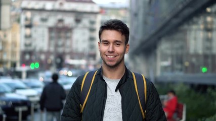 Portrait of Young happy smiling man standing in the street