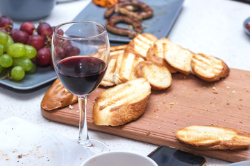 One of partying girls clinking flutes with sparkling wine. Girls hand with rings hold a glass of red wine