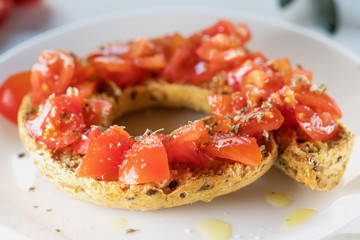 Tipical summer dish of Puglia - friselle. Classical frisella with tomato, oregano and olive oil. Dried bread called freselle. Healthy vegetarian food.