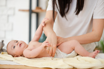Fototapeta na wymiar Mother hands put diaper on baby girl