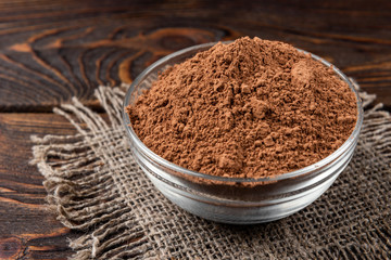 Cocoa powder on dark wooden background
