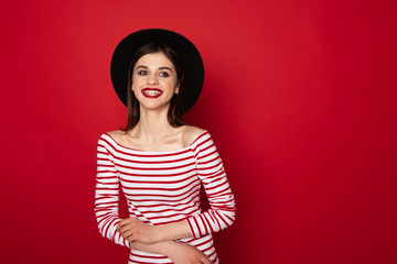 Happy cute girl in striped blouse and black hat