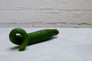 Organic ugly cucumber on a neutral background. Image with copy space.
