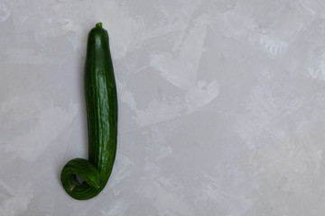 Organic ugly cucumber on neutral background. Image with copy space, top view.