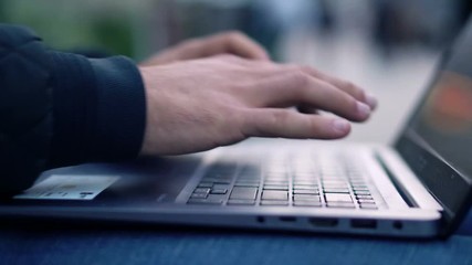 Close-up View of Man Using Laptop in the city street with bokeh effect