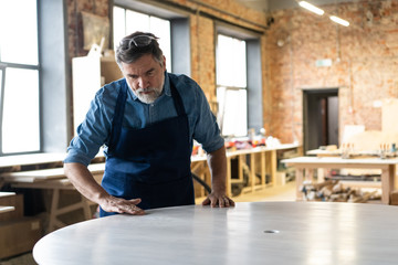 Mature handsome joiner work in carpentry. He is successful entrepreneur at his workplace.