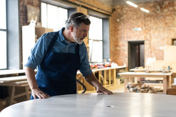 Mature handsome joiner work in carpentry. He is successful entrepreneur at his workplace.