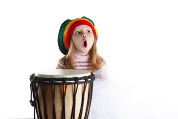 Expressive toddler girl portrait in rastafarian hat with drum