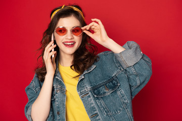 Smiling hipster girl talking by mobile phone
