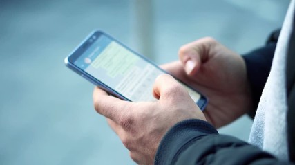 Close-up View of Man Using Smartphone in the city street