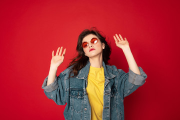 Cute hipster girl posing isolated on red