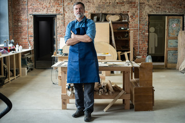 Mature handsome joiner work in carpentry. He is successful entrepreneur at his workplace.