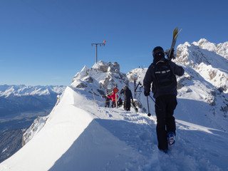 Turistas caminando con el equipo de esquí, por el  paisaje nevado de las montañas del Nordkette...
