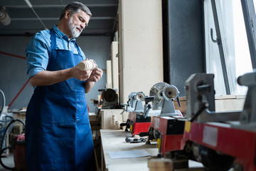 Mature handsome joiner work in carpentry. He is successful entrepreneur at his workplace.