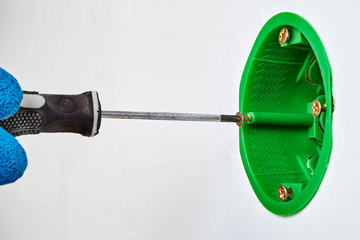 Tightening screw in new round electrical box.