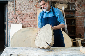 Mature handsome joiner work in carpentry. He is successful entrepreneur at his workplace.