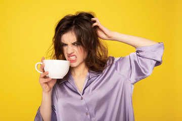 Angry young girl with cup of coffee