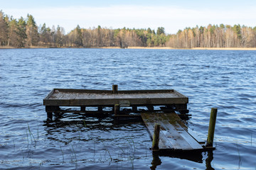 A wooden fishing bridge over a small lake. A place to catch fish.