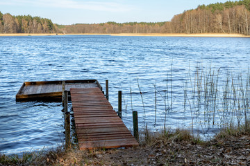 A wooden fishing bridge over a small lake. A place to catch fish.