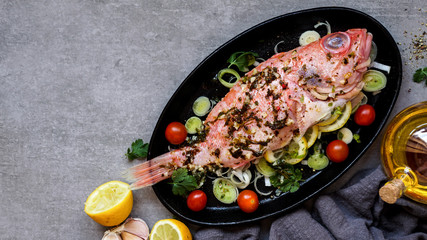 raw fresh ocean perch, ready to cook, olive oil, lemon, on the grey stone backgropund