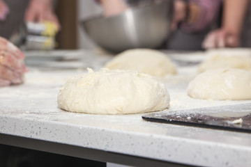 Cooks roll the dough for baking, pieces of raw dough on the Board