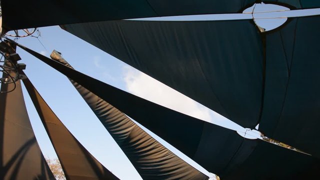 Sunshade shelter at dusk. blue awning canopy in the wind