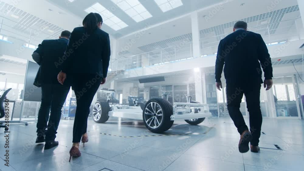 Poster team of automobile design engineers enter automotive innovation facility. start working on electric 