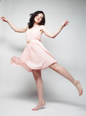 Naklejka premium young woman with curly hair wearing pink dress