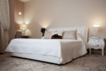 Fototapeta na wymiar Luxury design interior of hotel room in soft brown and beige color tone. Peace and quiet. Sweet home. King size bed in the middle of the room. Blurred. Abstract. Unfocused.