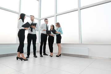 staff with business documents standing in the spacious office lobby