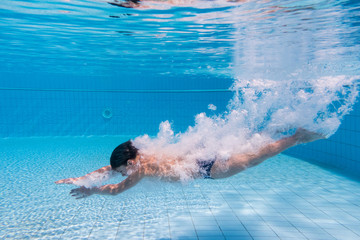 Boy dive in swimming pool
