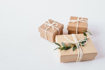 Craft gift boxes on white wooden background. Copy space for text. Eco concept