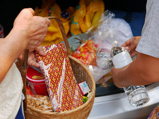 Selective focus of Thais preparing stuff from the back of their car for Rod Nam Dam Hua ceremony, paying respect to the elders, during Songkran festival in Thailand