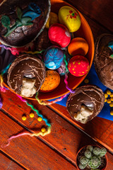 chocolate easter eggs and painted in an orange wooden font on a table, decorating sprinkles