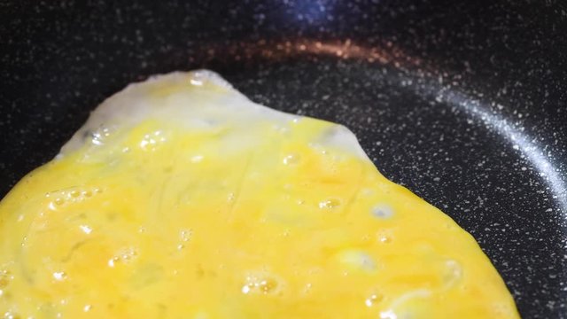 フライパンに溶き卵を注ぐ