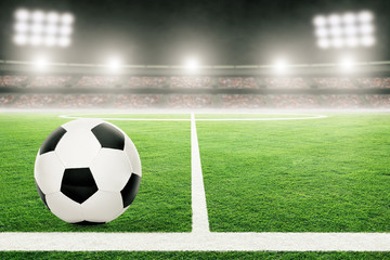 Fototapeta na wymiar Football on Soccer Field With Stadium Lights and Copy Space