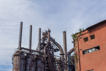 Fototapeta na wymiar Stacks blast furnaces with rusting exterior, abandoned industrial landscape, horizontal aspect