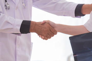 Obraz premium The senior doctor hand in with the nurse.