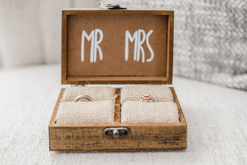 Open wood jewelry box with Mr and Mrs text containing wedding rings