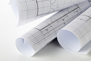 Rolls of architectural blueprint house building plans on white table background