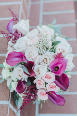 Pink roses and Calla Lily bridal bouquet on red brick stairs