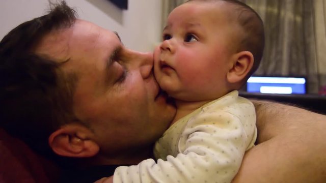 Six months old baby boy and hs father enjoing some quality time together. Father and son cuddling