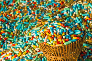 Many colorful medicines expire in bamboo weave basket  package  on cement floor,soft focus