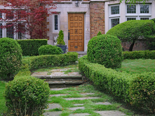 flagstone path leading to front door of house, with low hedge
