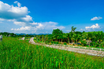 Obraz premium street view with green mountain on blue sky background in the province of Thailand. decoration image contain certain grain noise and soft focus.
