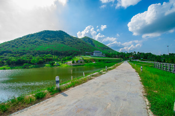 street view with green mountain on blue sky background in the province of Thailand. decoration image contain certain grain noise and soft focus.