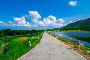 Fototapeta na wymiar street view with green mountain on blue sky background in the province of Thailand. decoration image contain certain grain noise and soft focus.