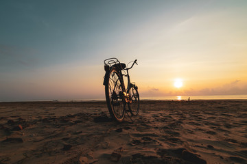 Fototapeta na wymiar Bicycle on the beach at sunset