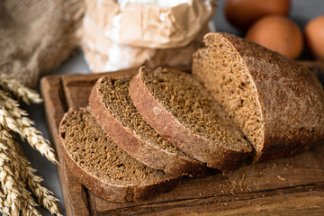 Rye bread sliced on wooden cutting board, selective focus. Homemade bread